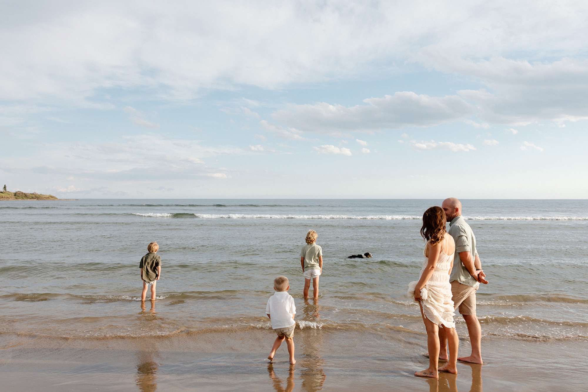 A family playing in the shallows on a calm afternoon