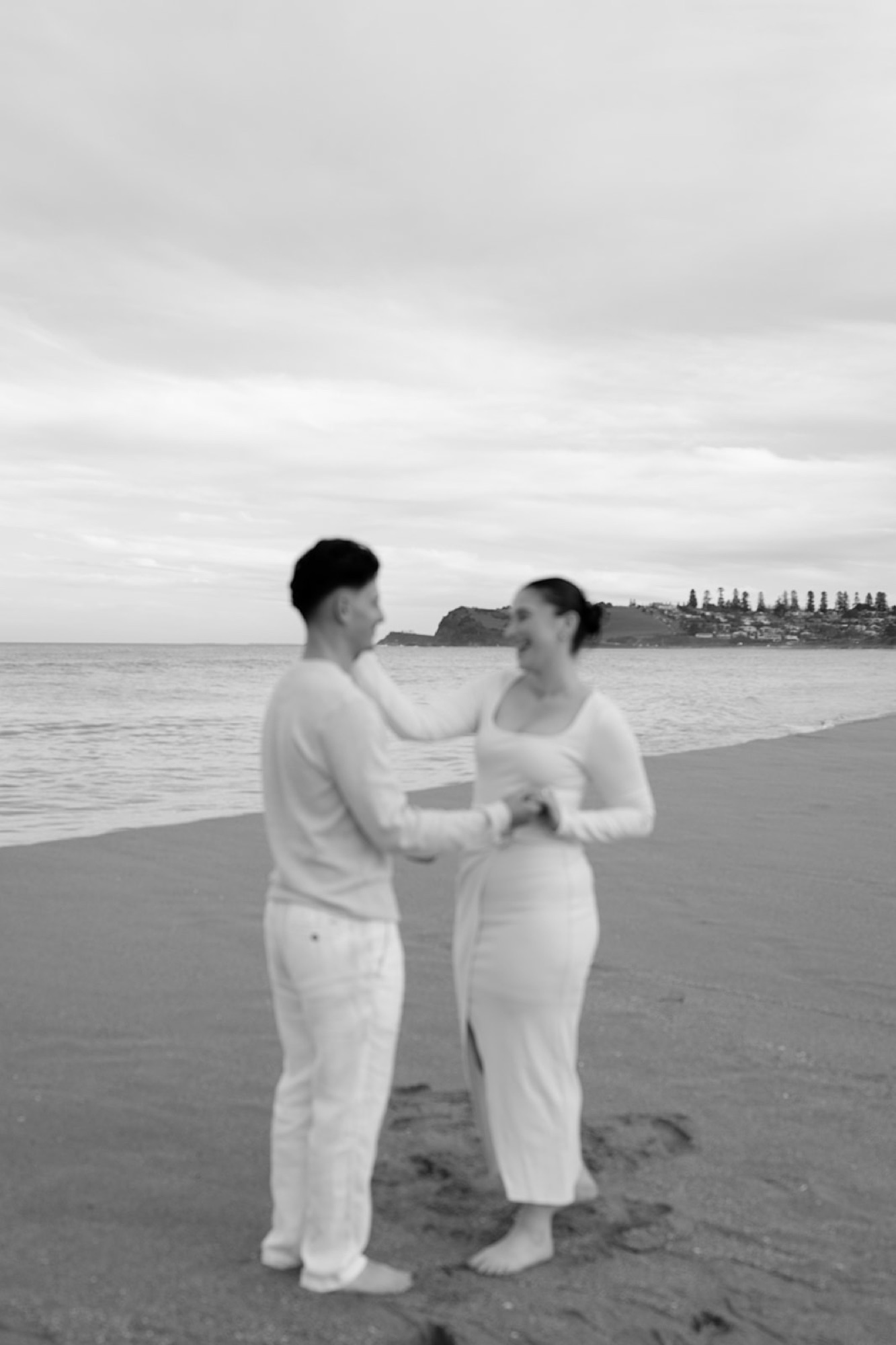 Black and white photo of a couple holding each other on the beach
