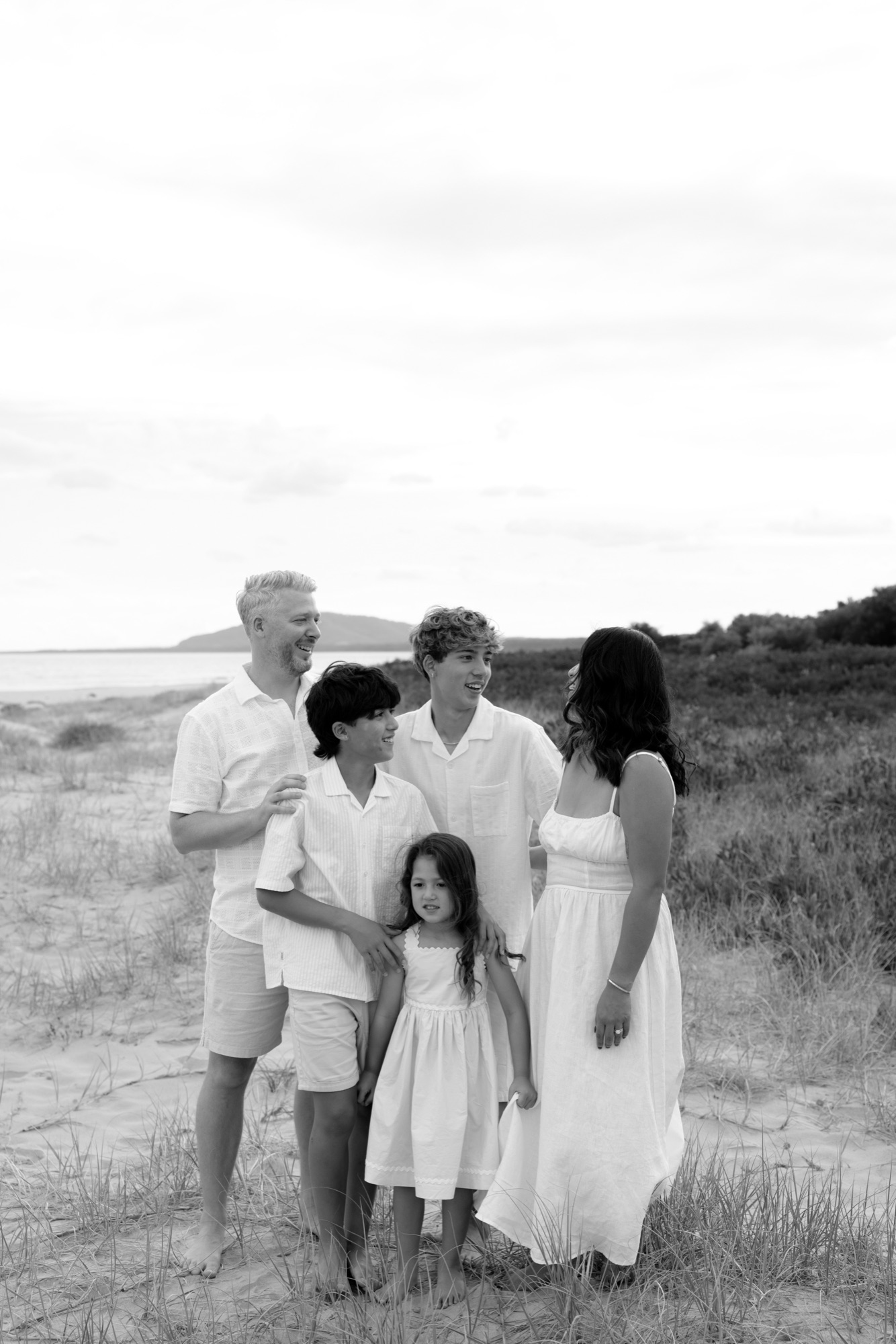 Black and white photo of a family standing together in the dune grass